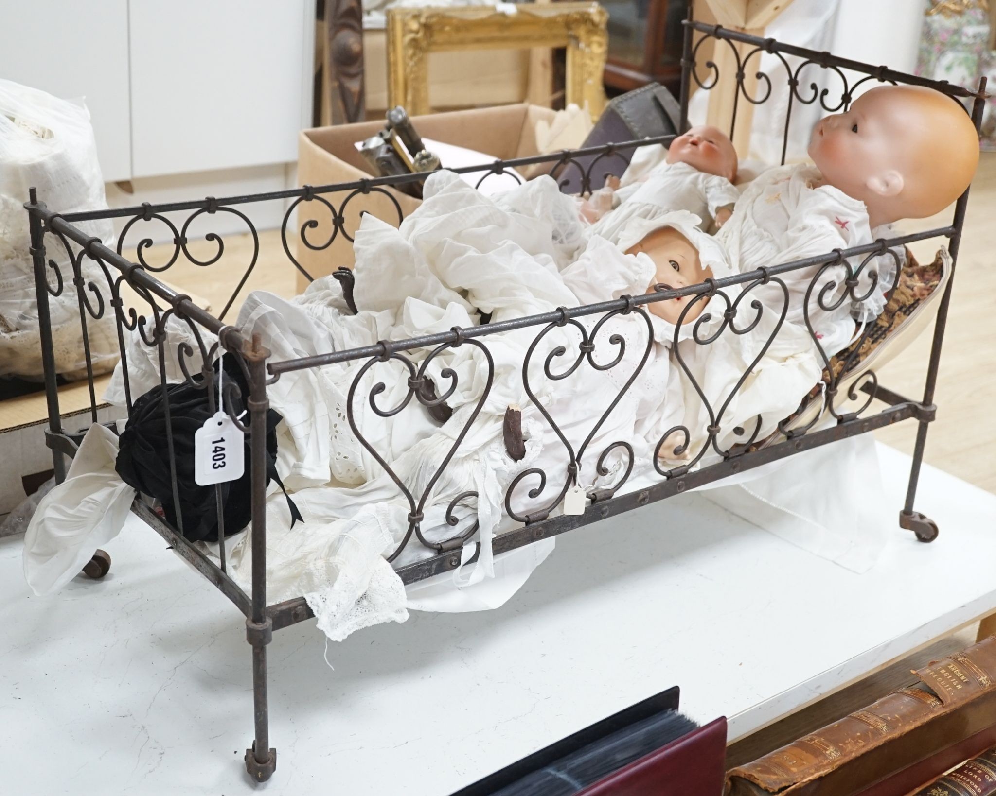 3 Armand Marseille bisque head dolls with sleeping eyes and 4 others in a wrought iron dolls crib 80cm
